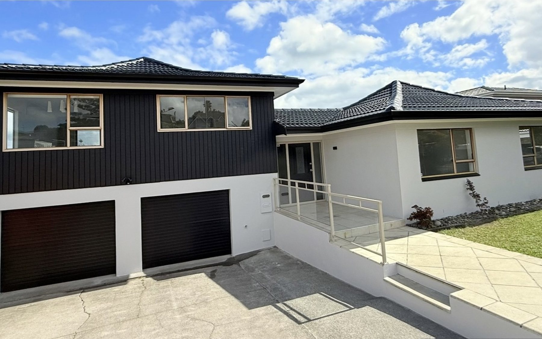 After: two-storey home, scaffolded with cream brick and tired cladding, then finished in black cedar and white